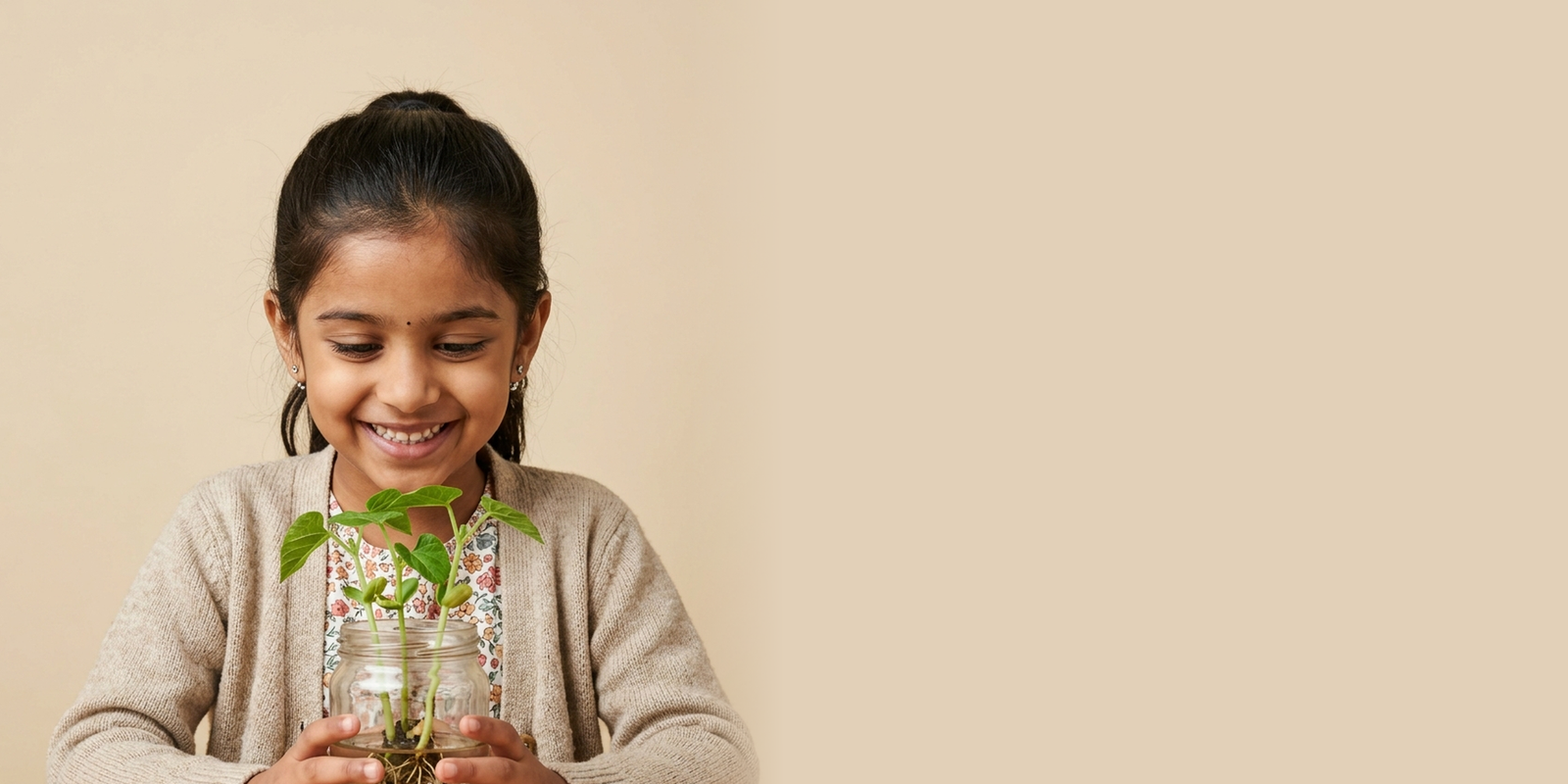 A child holding a terracotta pot with a seedling sprout